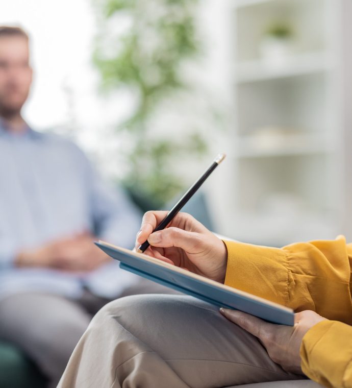 Doctor making notes Psychologist woman doctor making notes consulting male patient in bright office, healthcare concept, hands section